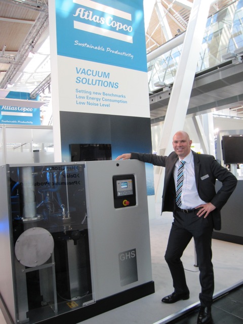 Conrad Latham, from Atlas Copco, next to the GHS 1900VSD 37 kW rotary screw vacuum pump for 0,35 mbar with the standard low-sound enclosure